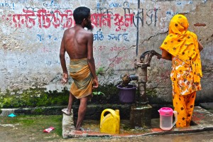 <p>A husband and wife fill up water containers from a tube well in Bangladesh. Photo by Laura Wright.</p>
